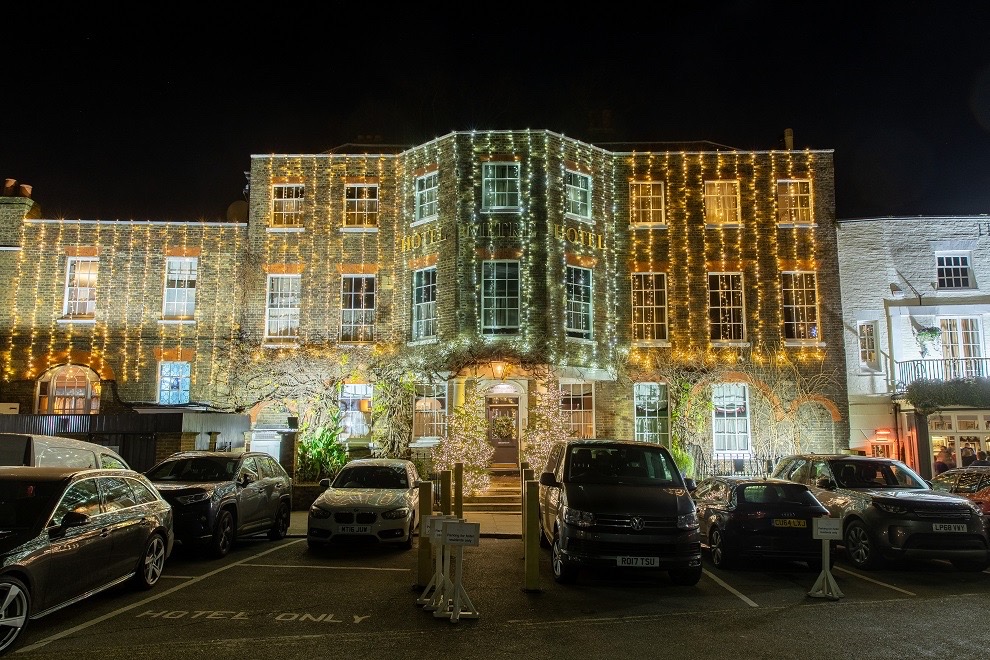 The front of The Mitre Hotel covered in fairy lights at night